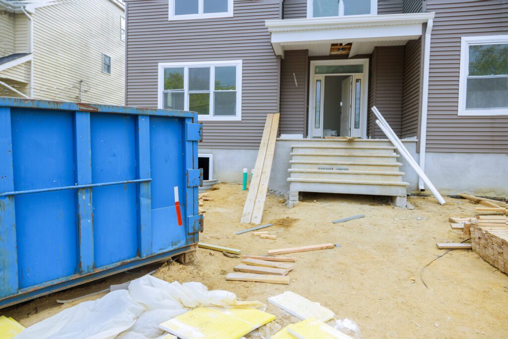 a dumpster in back of a house that is undergoing construction