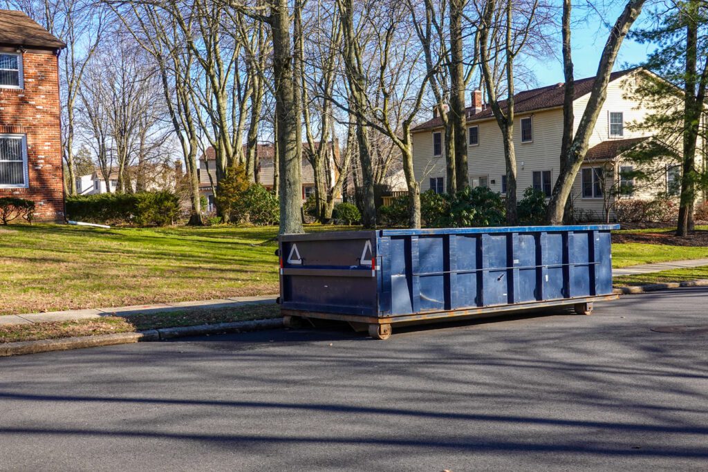 a long blue dumpster on a street